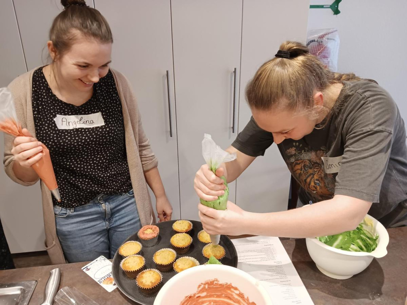 Freiwillige verzieren Cupcakes ein großen Backen